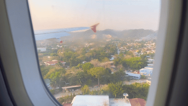 This clip features a moving commercial aircraft on a flight from Guatemala City to Flores, Guatemala. The city of Flores is visible below as the plane approaches the runway at Mundo Maya International Airport.