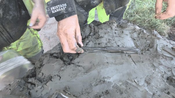 Man removing bone dagger from mud