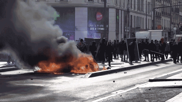 A gif of Protesters burned trash cans and plastic containers near a campus in the Paris